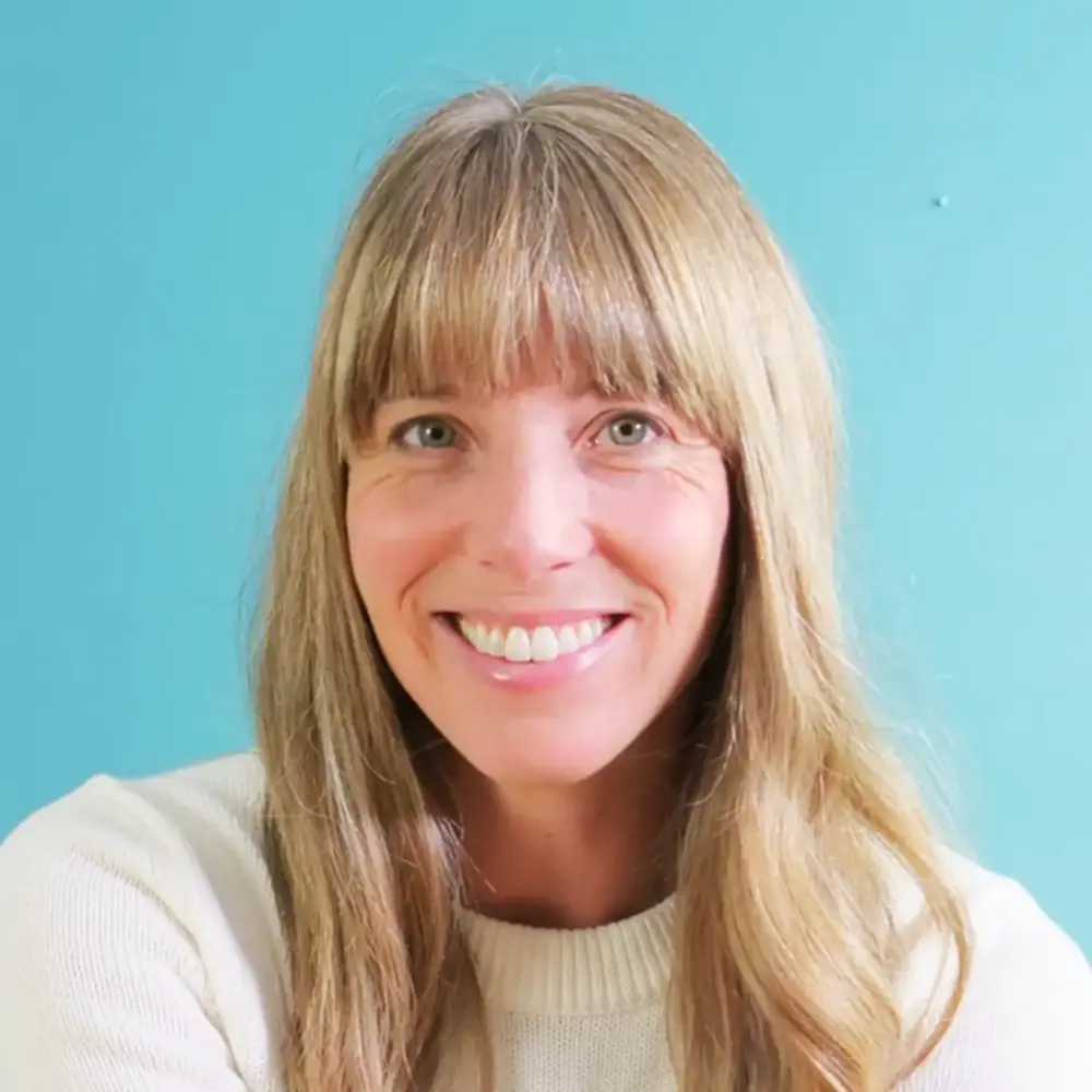 Amanda Jane Smith headshot, smiling against a teal wall