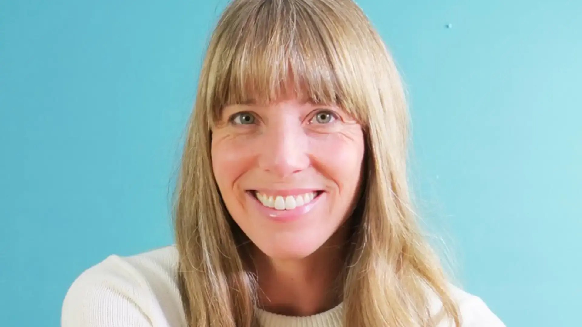 Amanda Jane Smith headshot, smiling against a teal wall